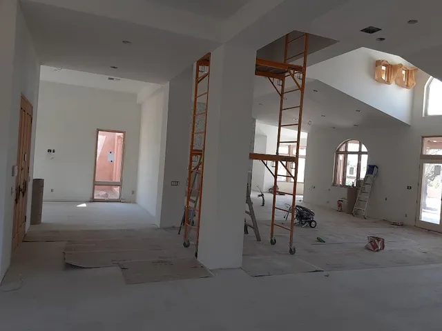 Freshly primed white walls with rolling scaffolds in a high-ceiling Phoenix great room
